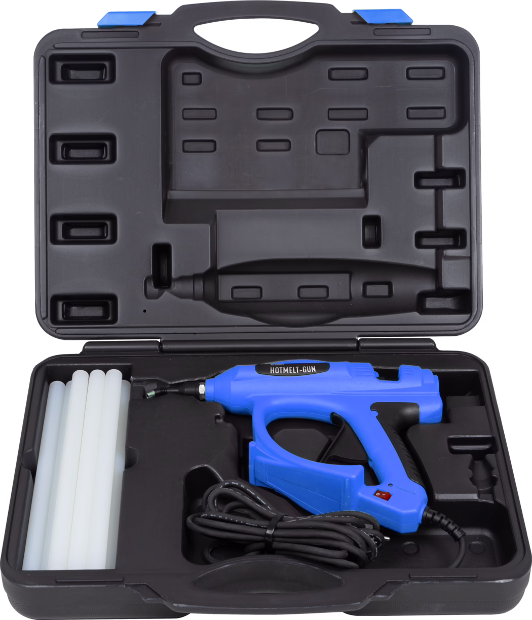 UZIN_Dummy_Hotmelt Gun-Composing_2023-10 Close-up view of a blue hot glue gun kit inside a black molded plastic carrying case. The upper lid shows empty molded compartments and a built-in handle; the lower section holds a blue hot melt gun labeled "HOTMELT-GUN", several white glue sticks on the left, a coiled black power cord and shaped recesses for accessories. The case is made of rigid black plastic with grooves and clips for secure storage and transport.